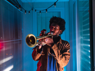 Young trumpeter performs at home - obrazy, fototapety, plakaty
