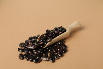 Scoop with black beans on beige background