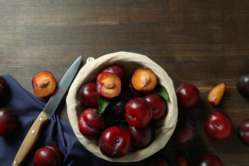 Concept of tasty food with plums on a wooden table