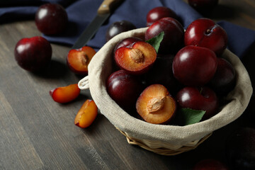 Concept of tasty food with plums on a wooden table