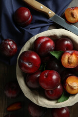 Concept of tasty food with plums on a wooden table
