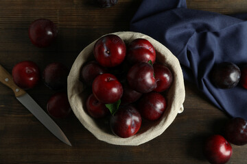 Concept of tasty food with plums on a wooden table