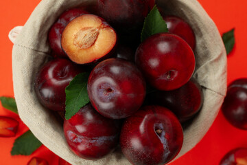 Decorative bowl with plums on an orange background