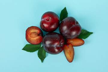 Plums with leaves on a blue background