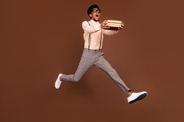 Fototapeta na wymiar Full length body size view of attractive cheerful funny guy jumping carrying science book isolated over brown color background