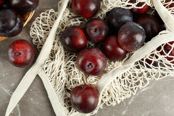 Concept of fruits with plums on gray textured table