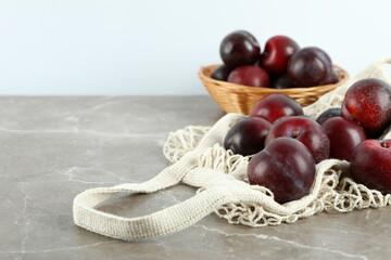 Concept of fruits with plums on gray textured table