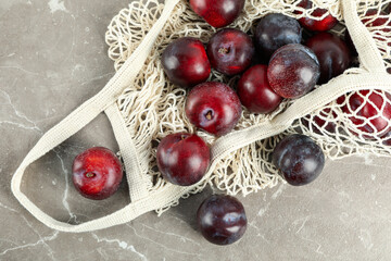 Concept of fruits with plums on gray textured table