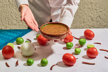 Young man showing traditional homemade Mexican salsa. Healthy Mexican food concept.