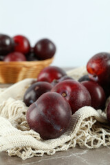 Concept of fruits with plums on gray textured table