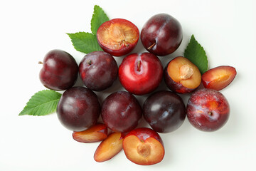 Tasty plums with leaves on white background