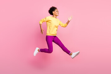 Photo of beautiful sweet woman dressed yellow sweater smiling jumping high running fast isolated pink color background