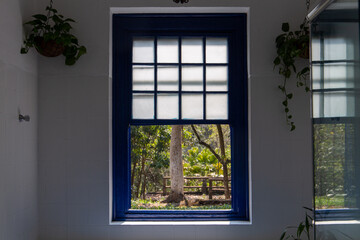 window overlooking nature on a farm in São Paulo, Brazil. Blue, old colonial windows. with white curtain