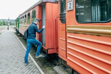 A man climbs a step entering a train of regional lines