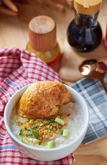Porridge and croissant in white bowl