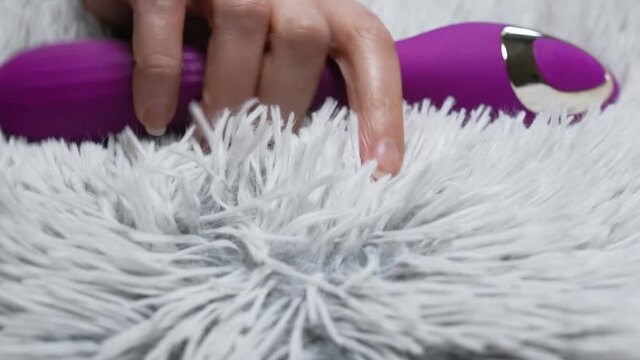 Woman taking pulse vibrating g-spot stimulator.
