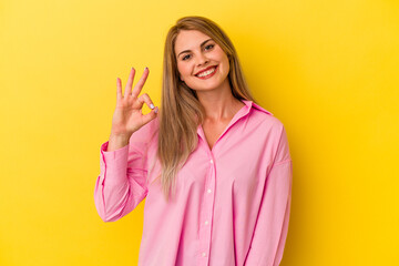 Young russian woman isolated on yellow background cheerful and confident showing ok gesture.