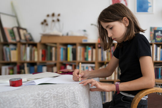 Young girl doing her homework in living room