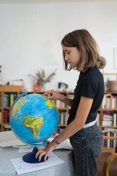 Young girl looking at globe