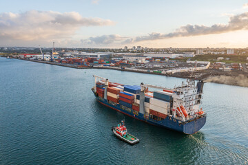 A pilot boat is guiding a cargo ship to dock.