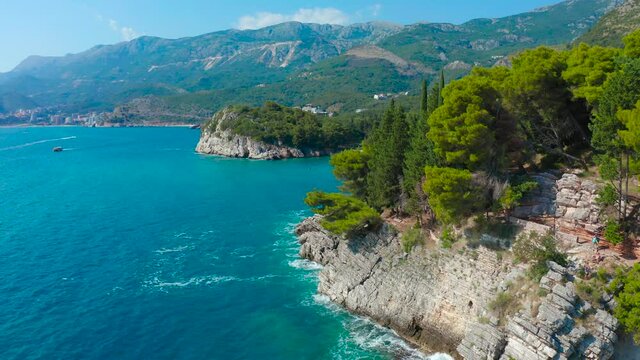 Landscape on Montenegrin coast with clear water and pine trees around. Aerial view 4K.