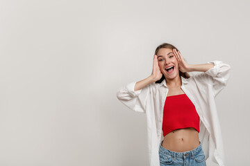 Image of excited screaming young woman screaming and holding hands hear face isolated over white background. Looking at camera