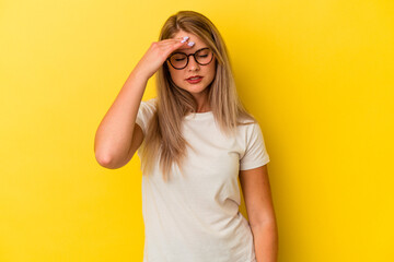 Young russian woman isolated on yellow background touching temples and having headache.