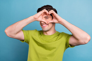 Photo of coquette millennial brunet guy hands heart wear green t-shirt isolated on blue color background