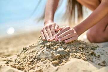 Close up picture of hands making castles from sand