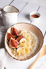 Breakfast with oatmeal porridge decorated with figs and bananas