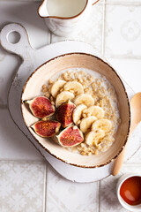 Close up of bowl with porridge with fruits and nuts for breakfast
