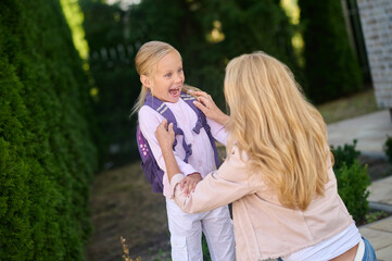 Woman crouching beside an enthusiastic little girl