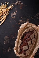 Freshly baked homemade bread on artisan sourdough rye on brawn stone or concrete background. Top view. Food cooking background. Copy space.