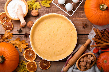 Pumpkin and food ingredients, spices, cinnamon and kitchen utencil on old rustic wooden background. Concept homemade baking for holiday. Cooking pumpkin pie and cookies for Thanksgiving day.