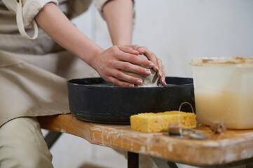 Close up of human hands molding clay on a pottery wheel