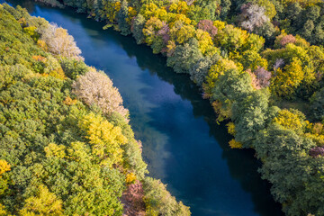 Aerial view to autumn forest with river bend, natural colorful background