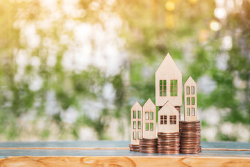 Wooden houses model put on the stack gold coin it show present for choose and buying is owner home...