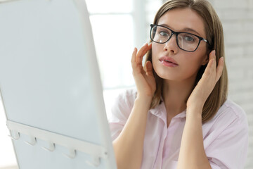 Woman with poor eyesight. A beautiful girl wears glasses to improve her vision. High quality photo