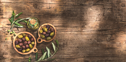 Rustic, village, wooden olive background or internet banner with olive oil and olive branches, sunlight for graphic design and text, copy space, flat lay. Healthy mediterranean food concept
