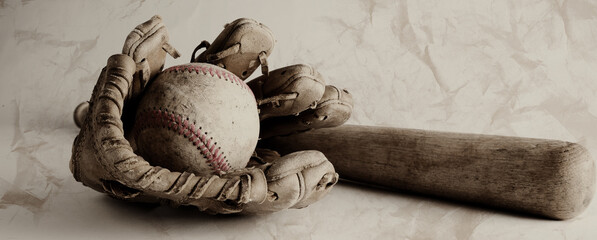 Rustic baseball equipment close up in wide angle with old texture over ball and glove with wooden...
