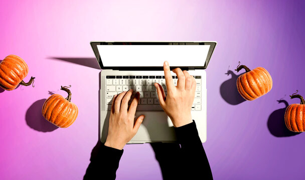 Autumn pumpkins with person using a laptop computer from above