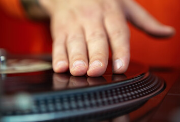 Hand of dj playing hip hop music with turntables and vinyl records. Professional analog audio equipment for disc jockey