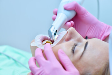Dentist in pink glove scanning teeth with 3d scanning machine.