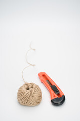 Closeup of a stationary knife and a yarn ball isolated on a white background