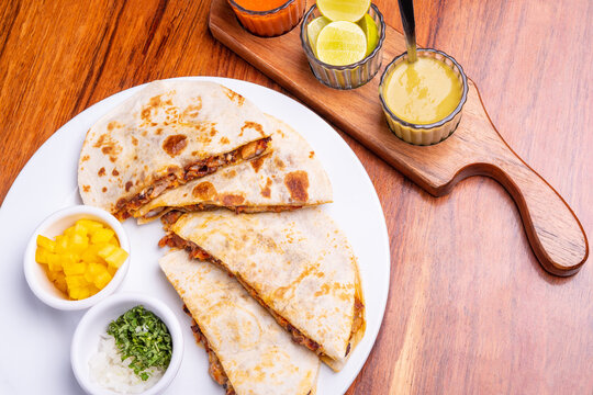 Shepherd's meat tacos with corn tortillas. Gringa with cheese. Mexican food on wooden background. Mexican gringa with hot sauce. Mexican taco concept. Mexican food concept.