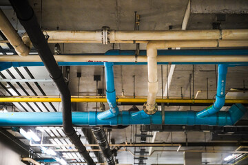 Electrical conduits system and metal pipeline installed on building ceiling.