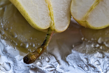 A yellow pear cut into two parts.