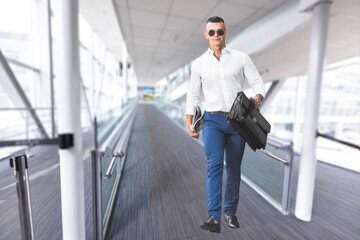 A handsome guy walking at the airport terminal, going to flight boarding,