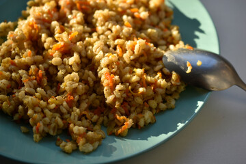 Boiled pearl barley with spices on a plate