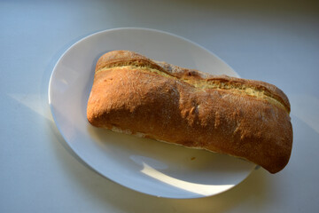 Fresh ruddy bread in chunks on a white plate